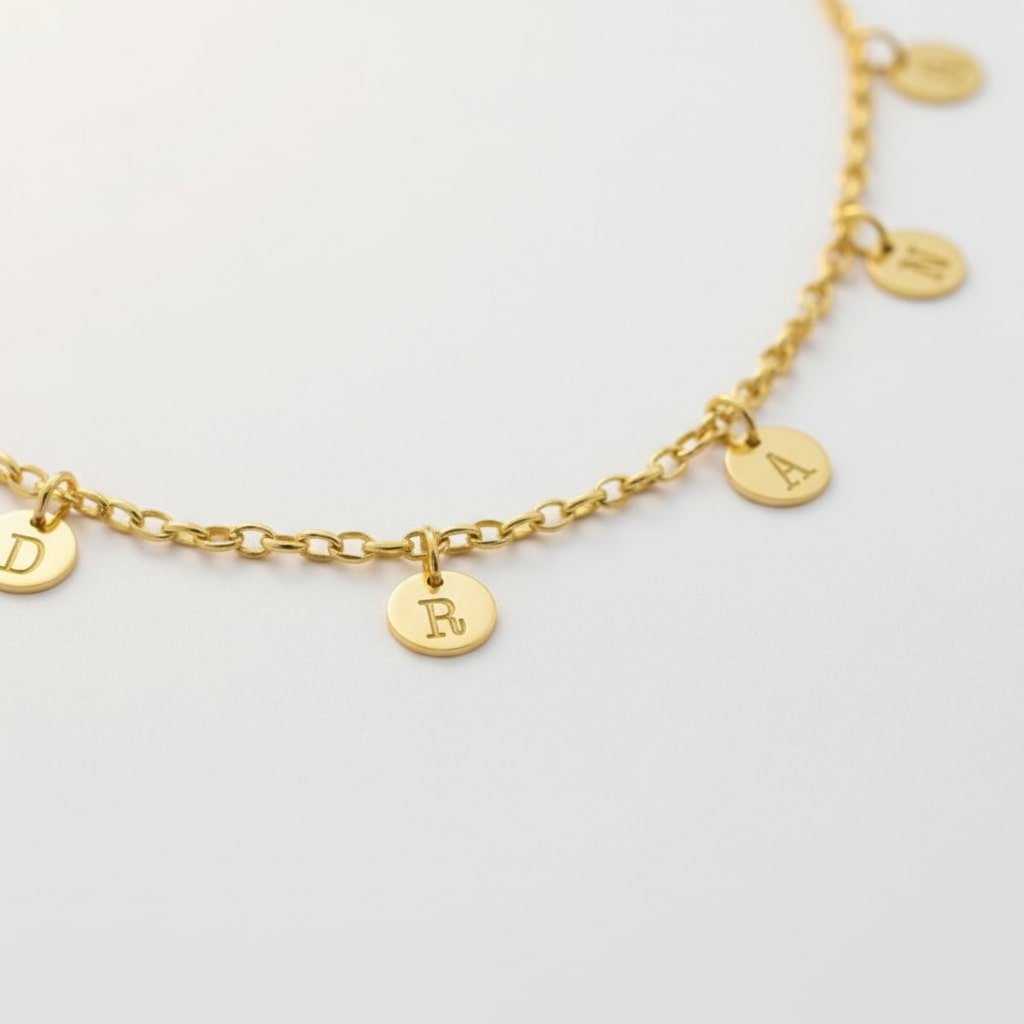 Goudkleurige Naamketting met Meerdere Rondjes Letters van Zilver Names4ever op tafel
